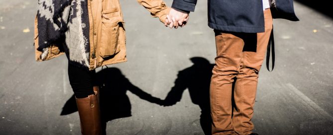 couple holding hands in winter coats