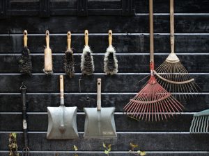 <view of garden tools organised on the wall of a garden shed>