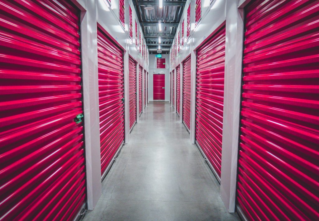 A self-storage building with red rollup doors serves as a way to declutter someone’s home.