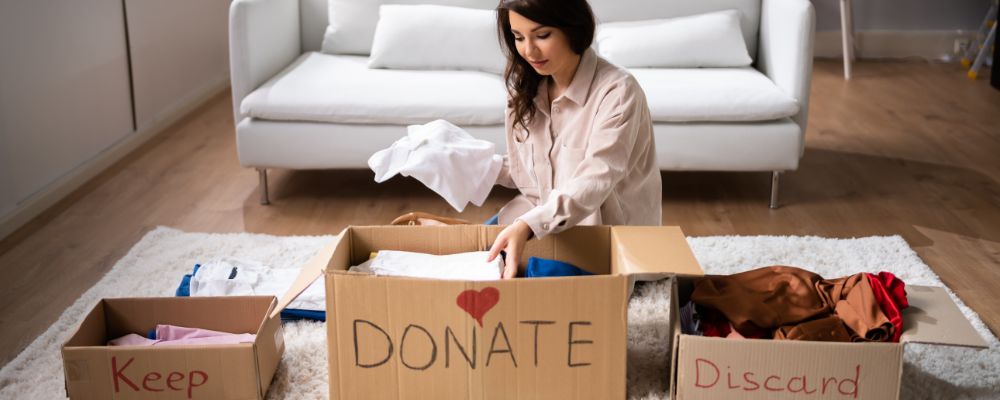 A woman sorts items into piles to keep, donate, and sell. 