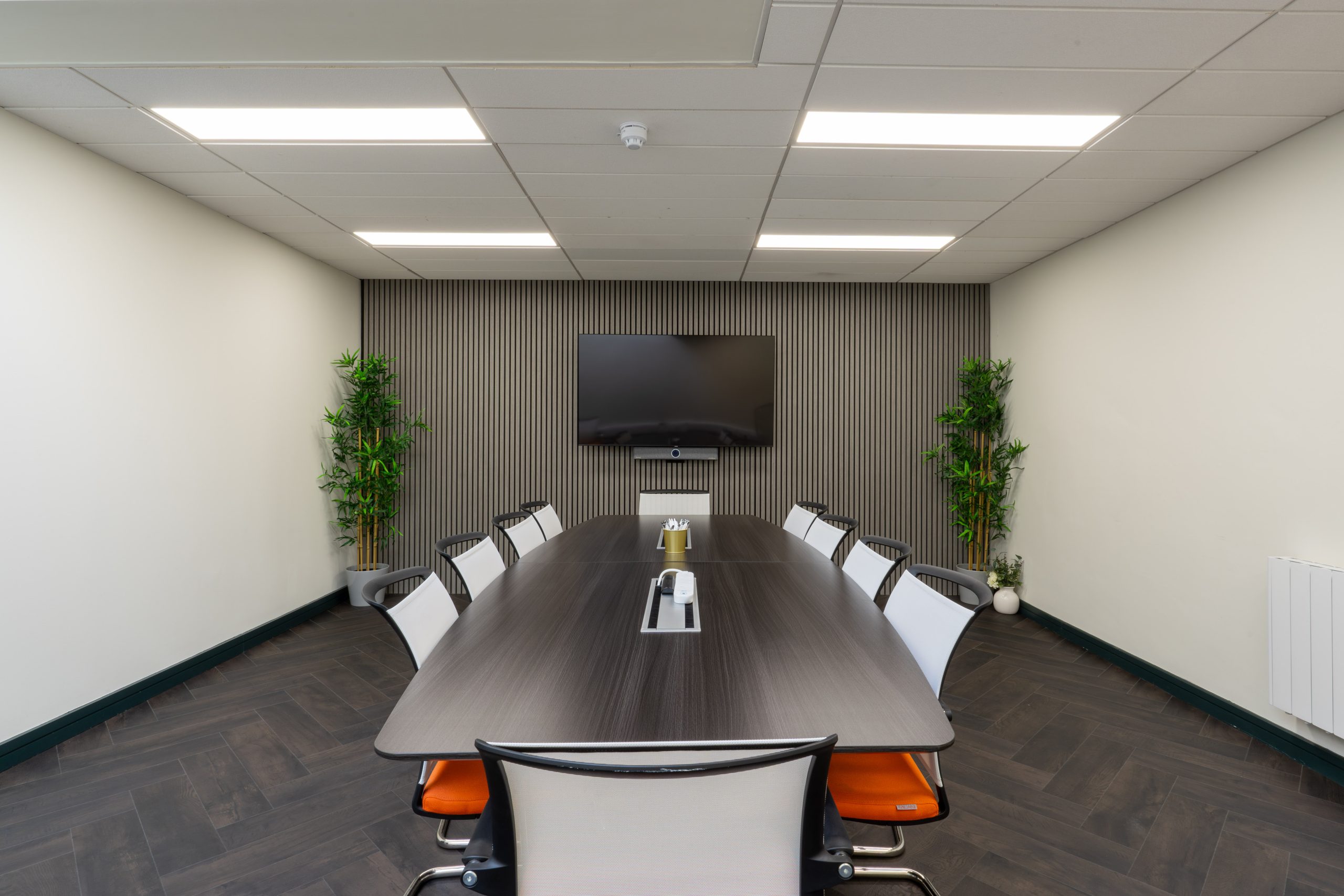 Boardroom conference room with large table chairs and a T.V screen