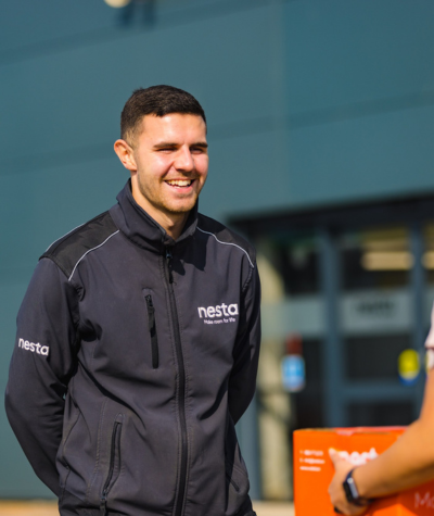 lovely clean jacket Employee of nesta smiling at customer