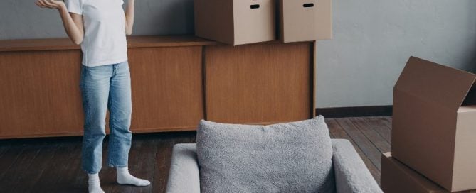 woman moving out of her apartment surrounded by boxes and furniture